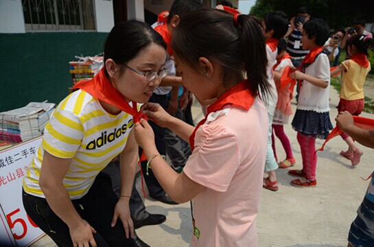 捐贈儀式上，孩子們?yōu)閻坌奶焓瓜瞪霞t領(lǐng)巾