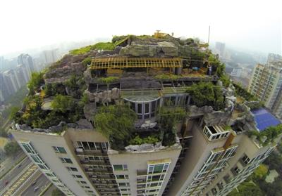 　　昨日，身穿橘黃色馬甲的工作人員在人濟(jì)山莊樓頂拆除違章建筑。新京報(bào)記者 吳江 攝