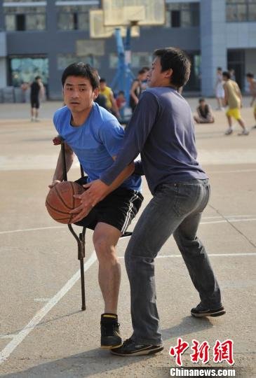 圖為拄著拐杖的瞿詩(shī)濤和同學(xué)搶球。劉占昆攝