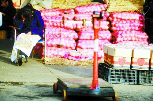 水果批發(fā)市場內(nèi)，沒有客戶時，商戶在繡十字繡