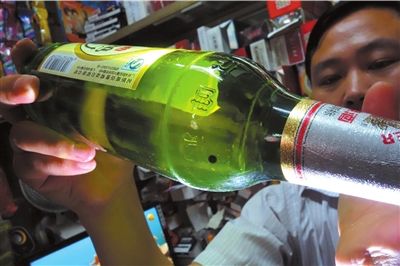 這瓶未開封的燕京啤酒內(nèi)有一顆黑色懸浮物。京華時報(bào)記者 徐曉帆 攝
