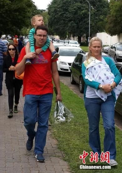 圖為一個(gè)白人家庭,由父母帶著孩子到曼德拉家門(mén)外悼念。中新社發(fā) 宋方燦 攝 圖為一個(gè)白人家庭,由父母帶著孩子到曼德拉家門(mén)外悼念。中新社發(fā) 宋方燦 攝