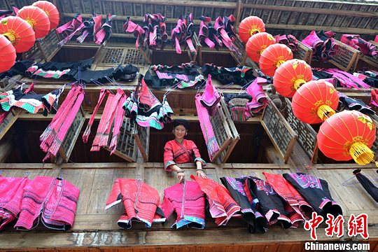 圖為紅瑤姑娘把紅衣晾曬出來。中新社發(fā) 韋吉陽 攝