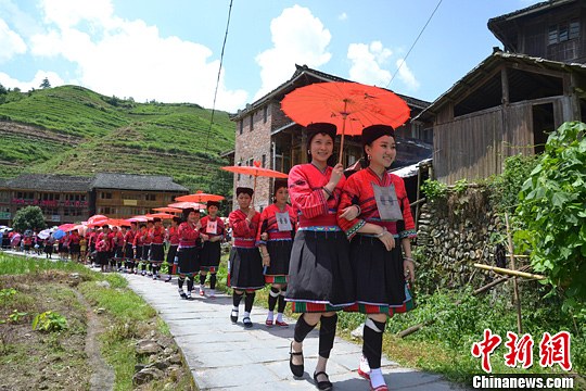 圖為新娘身著瑤族盛裝在伴娘和親友的陪伴下“出嫁”。中新社發(fā) 韋吉陽 攝