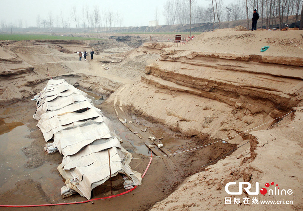 2014年1月6日，河南洛陽古沉船發(fā)掘現(xiàn)場，近日有雨雪天，考古人員給古沉船披上一層“雨衣”。