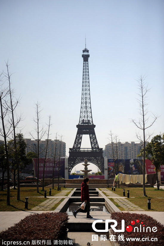 　2014年3月21日，杭州天都城，農(nóng)民在山寨埃菲爾鐵塔下耕作。圖片來(lái)源：東方IC