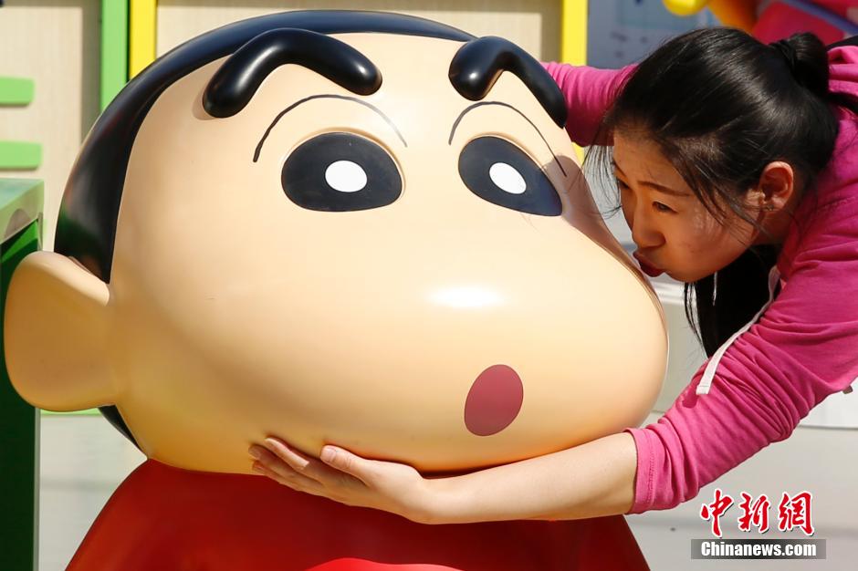 4月22日，游客與蠟筆小新合影?！跋灩P小新25周年紀(jì)念特展”日前在北京開(kāi)展，吸引了不少市民游客。