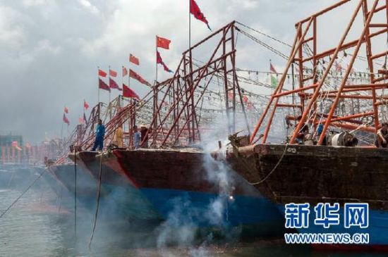 2013年8月1日 南海開漁日 臨高迎新港 8月1日，海南省臨高縣漁民在船上鳴放鞭炮慶祝武蓮港開港。