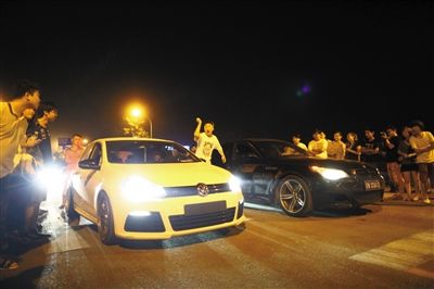 8月24日晚，東壩中街飆車現(xiàn)場，兩輛車并排等待出發(fā)指令，旁邊許多愛好者前來觀看比賽。新京報(bào)記者