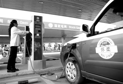 9月11日，懷柔區(qū)，電動(dòng)出租車司機(jī)正在為車輛充電。