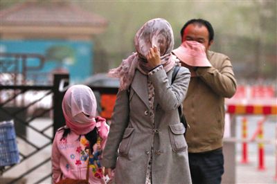 昨日下午，朝陽(yáng)區(qū)豆各莊，行人將紗巾裹在頭上防沙塵。