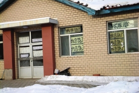 伊春市帶嶺區(qū)一排破舊的平房，房間窗戶上貼滿了“我告饒了”的字樣。