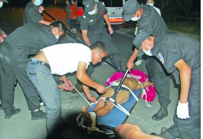 眾人合力將狂犬病發(fā)作的江某控制住。 孫東城 攝