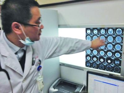 醫(yī)生在查看男孩的腦部CT片。薛馬義 攝