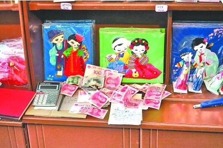 　　2012年6月21日，在朝鮮羅先特別市的一家商店里，柜臺上散落著一些人民幣。在朝鮮，人民幣比本國