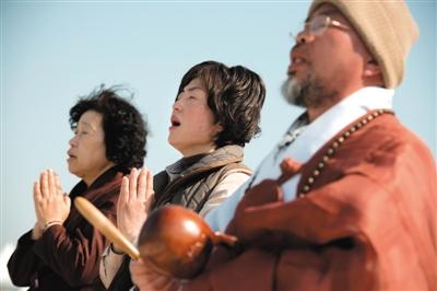 23日，一名僧侶引領(lǐng)人們?yōu)樗勒咂矶\。