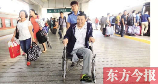 李剛手術(shù)后歸來(lái)，在車站工作人員幫助下走出鄭州火車站站臺(tái)  東方今報(bào)首席記者 張曉冬 攝