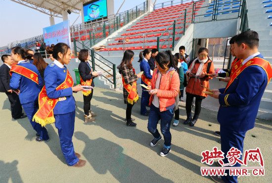 活動(dòng)現(xiàn)場(chǎng)工作人員給同學(xué)們發(fā)放宣傳冊(cè)、環(huán)保袋。