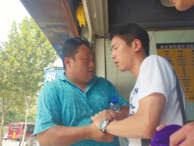 記者正查看照片，突遭藍(lán)衣男強(qiáng)搶手機(jī)。