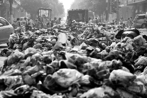 垃圾堆滿整個路口，環(huán)衛(wèi)工人們正在清理