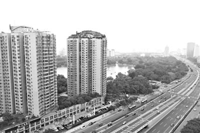 昨日，人濟山莊小區(qū)，與其他樓相比，B棟樓頂層天臺上違規(guī)建造了一棟兩層小樓，假山大樹俱全。新京報記者