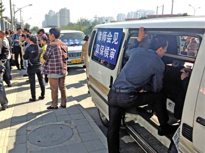 昨日，朝陽區(qū)看守所門前有人排隊。大門外還停有多輛寫有“律師會見”字樣的車。