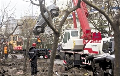 輸油管道爆炸后，搶修人員將被炸毀的車輛運出現(xiàn)場。