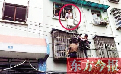 施救現(xiàn)場，劉鵬（圈內(nèi)）先用繩子捆住老太確保安全 勞動報記者 郭娜 供圖