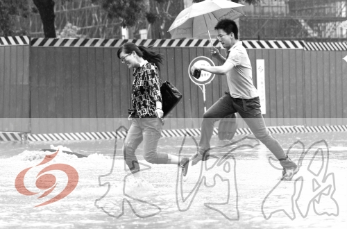 鄭州經(jīng)三路與北環(huán)交叉口處，積水較深，行人們不得不“練輕功”。 記者 白周峰 攝影