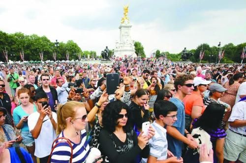 7月23日，在英國倫敦白金漢宮外，民眾們爭相閱讀“王室寶寶”出生的正式公告。