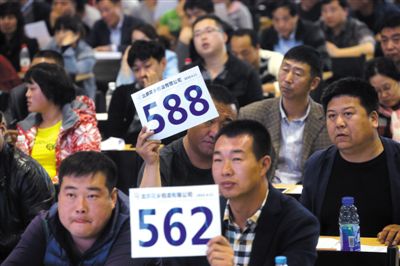 昨日，拍賣現(xiàn)場競拍者舉牌競拍。新京報(bào)記者