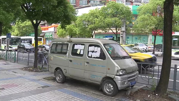 被棄置在人行道上的面包車。