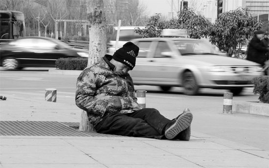 2月2日，鄭州市中州大道農(nóng)業(yè)路立交橋下，50歲的王文德打算在臨近春節(jié)前再接些零活兒，由于疲憊，他睡著