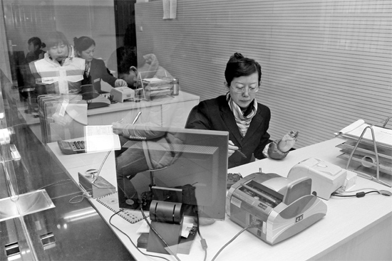 2月16日，鄭州市自來(lái)水總公司鄭東新區(qū)一營(yíng)業(yè)廳，柜臺(tái)內(nèi)工作人員正在為市民辦理業(yè)務(wù)