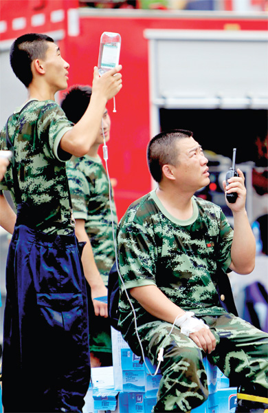 火場外，被消防戰(zhàn)士稱為“李大隊(duì)”的救援人員掛著吊瓶現(xiàn)場指揮