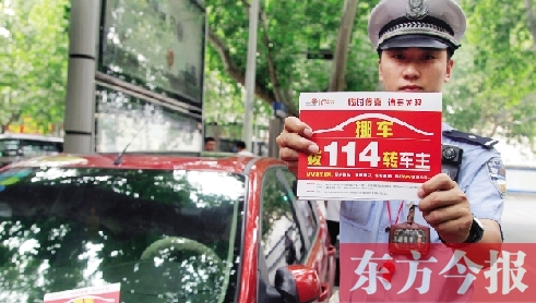8月27日，鄭州市緯一路與經(jīng)七路交叉口，交警將“挪車請(qǐng)撥打114轉(zhuǎn)車主”的提示牌放在路邊?？康能嚿? width=
