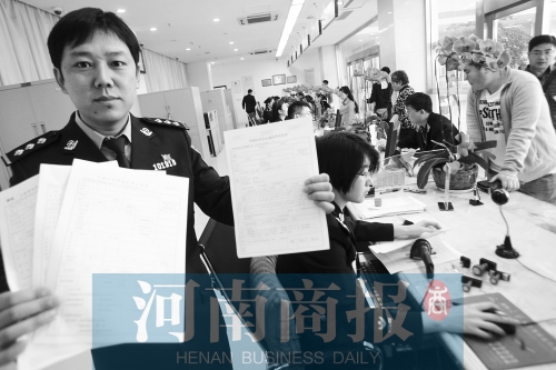 　民警左手拿的是新申請表，右手拿的是三份老申請表 王春勝/攝