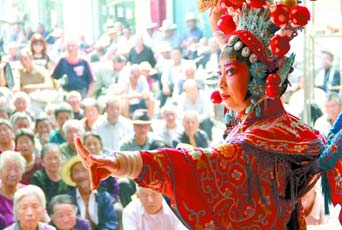 圖為8月15日戲曲演員在“流動(dòng)舞臺(tái)車”上表演傳統(tǒng)地方戲《穆桂英下山》。