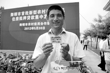 領(lǐng)到貸款，農(nóng)民開心地笑了。