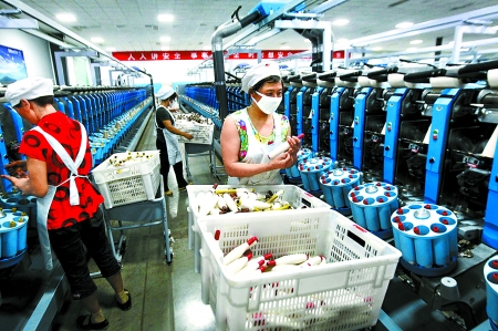 6月6日，舞鋼市鑫海紡織有限公司員工正在新建成的紡紗車間生產(chǎn)。