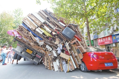 紅色小轎車被砸，卡在路邊動(dòng)彈不得。
