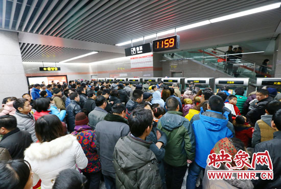 地鐵開通首日，上午十一點五十九分，紫荊山地鐵站售票機前擠滿了買票的市民。