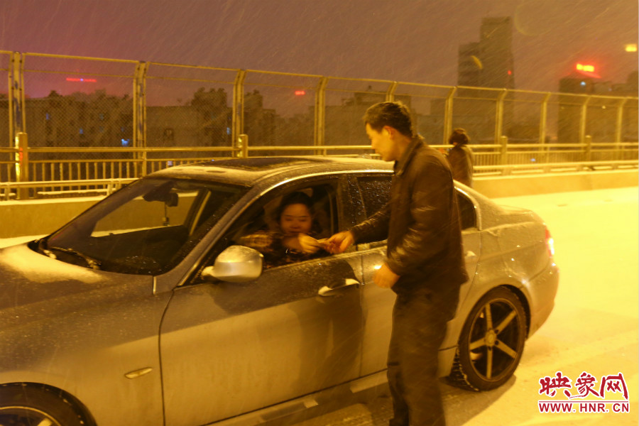 “推車人”幫助一輛車上坡后，收取“勞務(wù)費(fèi)”。