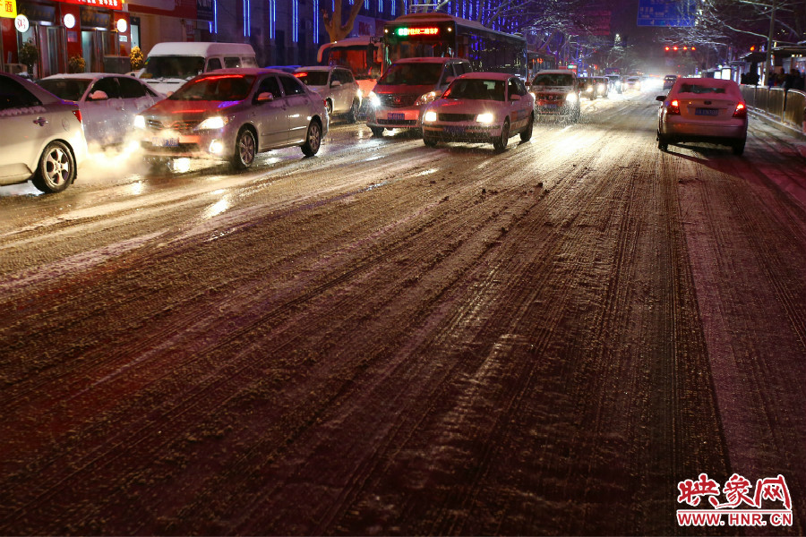 夜晚的雪路給出行的人們增加了困難。