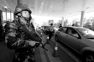 武警持槍警戒進(jìn)駐檢查站。 武警持槍警戒進(jìn)駐檢查站。