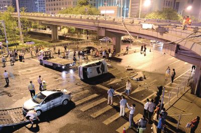 路虎沖下國貿(mào)橋砸中一輛起亞轎車，橋上厚達幾十厘米的水泥護欄被撞斷，碎石四處散落，數(shù)十群眾在現(xiàn)場圍觀。