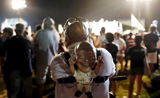 9月4日，新加坡，執(zhí)政黨的一場集會上，一名支持者背著一個李光耀的人偶。