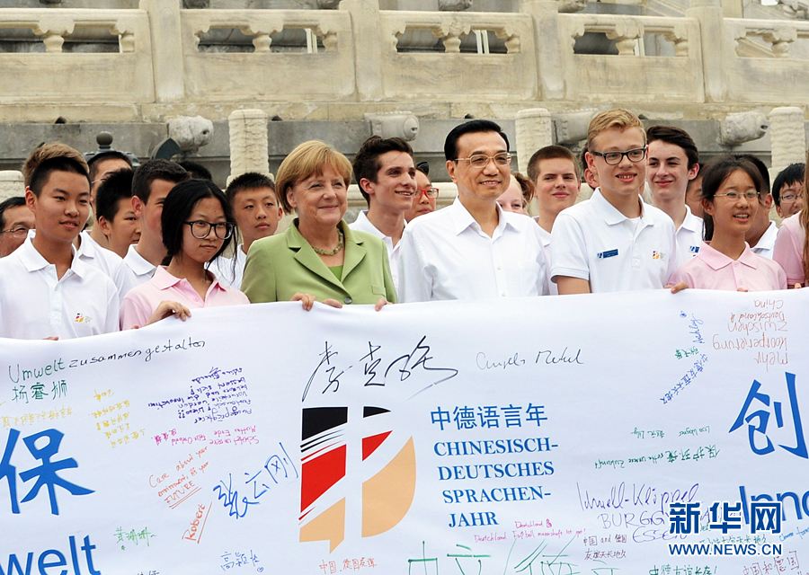 李克強(qiáng)同默克爾與青少年在天壇祈年殿前合影留念。