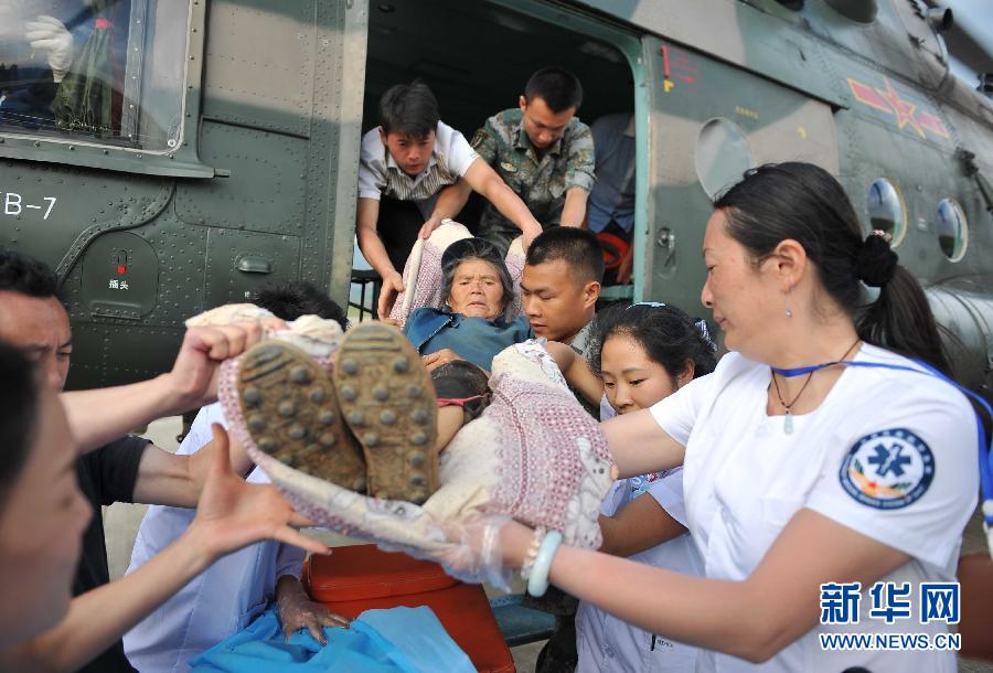 8月5日，醫(yī)護人員將一名通過直升機從震中轉(zhuǎn)運出來的傷員運下飛機。