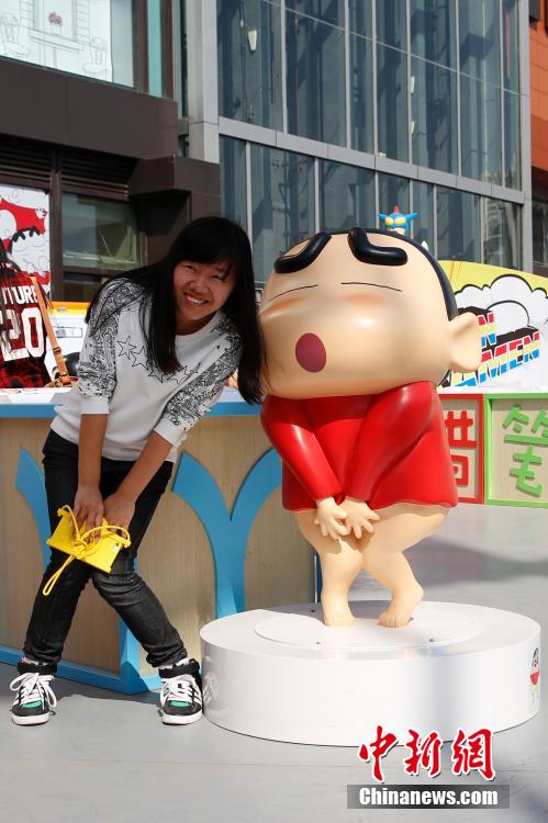 4月22日，游客與蠟筆小新合影?！跋灩P小新25周年紀(jì)念特展”日前在北京開(kāi)展，吸引了不少市民游客。